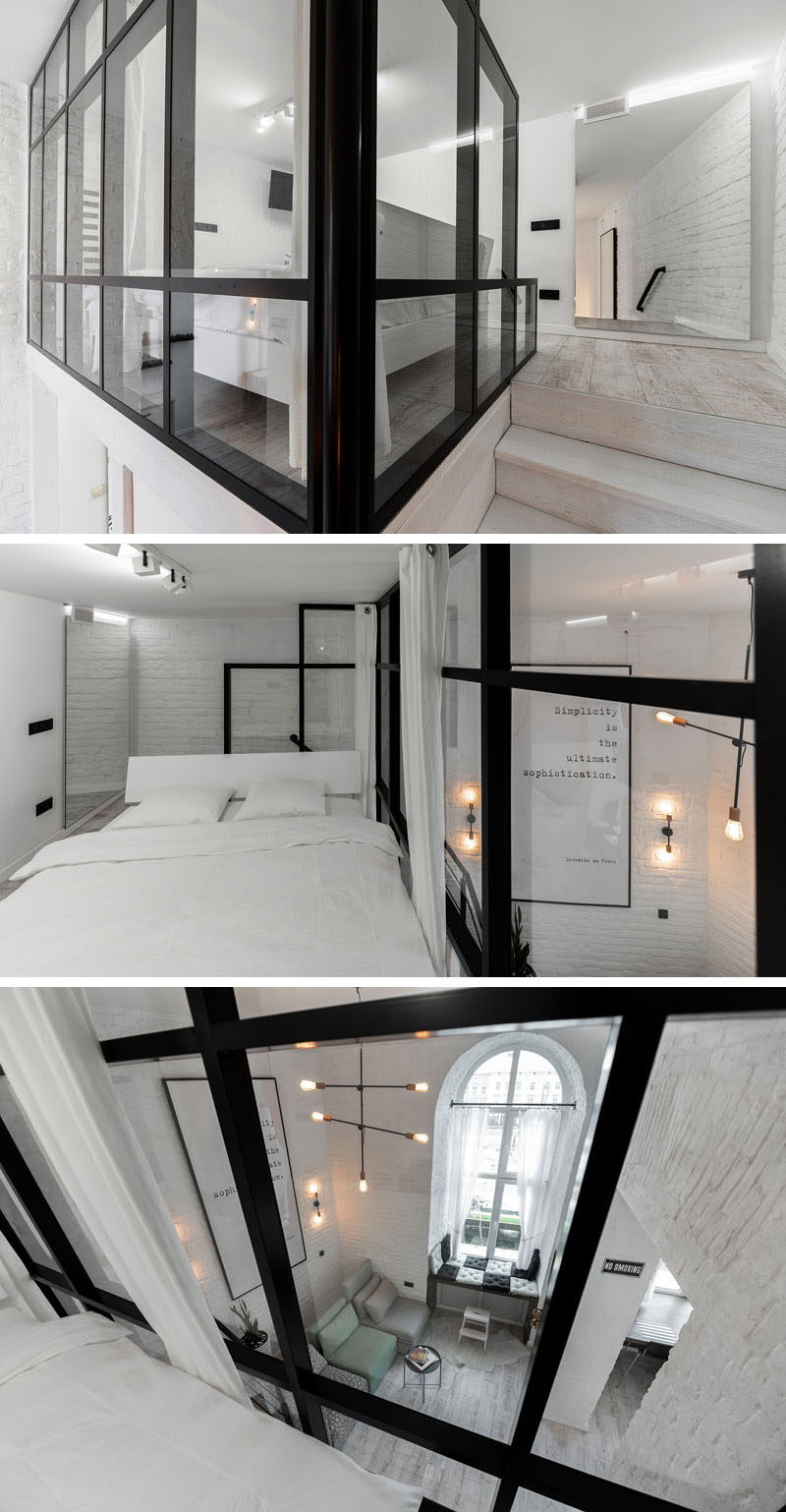 This modern mezzanine bedroom has a black-framed glass wall that overlooks the living room below. #Bedroom #ModernBedroom #GlassWall #MezzanineBedroom