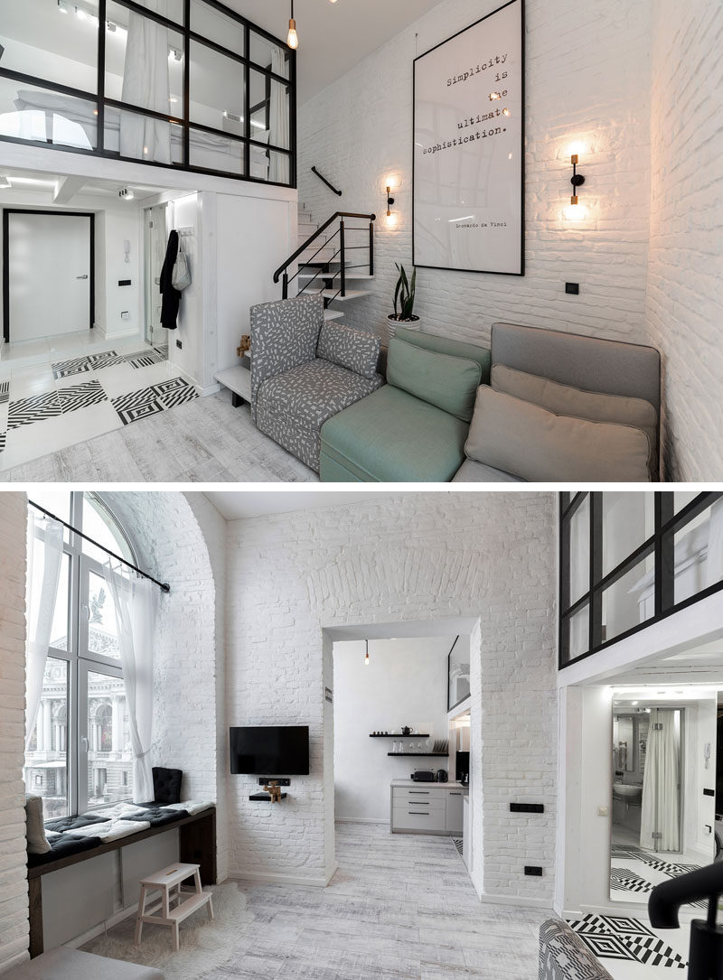 This modern loft apartment features high ceilings, painted brick walls, and a mezzanine with a bedroom and reading room. #LoftApartment #MezzanineBedroom #InteriorDesign #ModernApartment