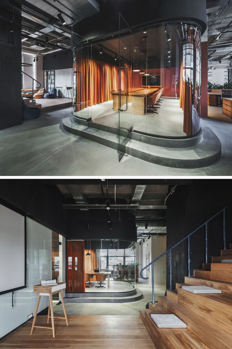 This modern office in Russia features a meeting room that's slightly raised and enclosed in a room with curved glass walls. #ModernOfficeDesign #OfficeInterior