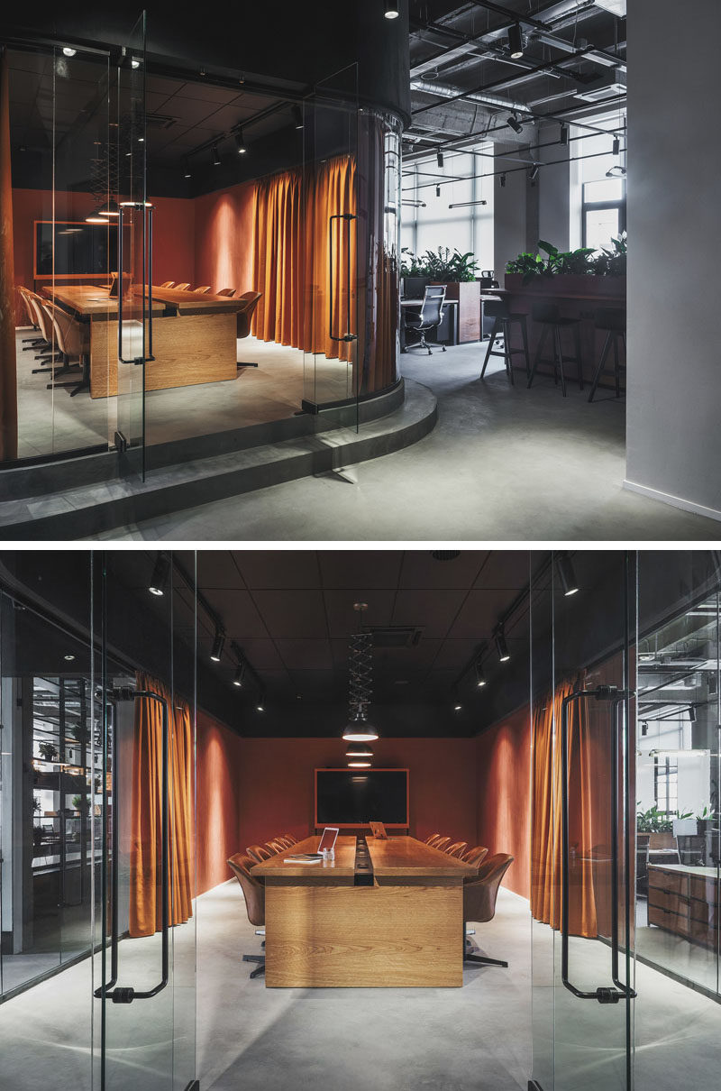 This modern office in Russia features a meeting room that's slightly raised and enclosed in a room with curved glass walls. #ModernOfficeDesign #OfficeInterior