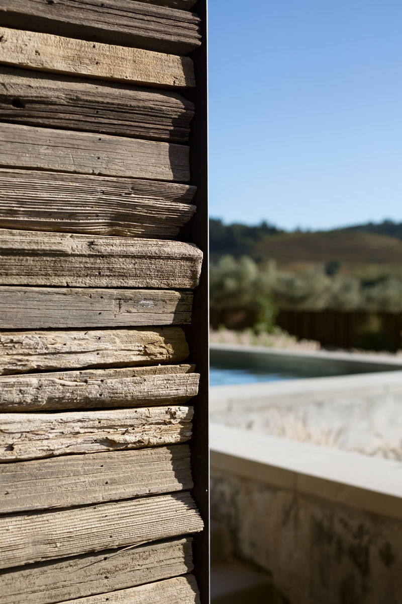 The exterior of this modern pool house features wooden stakes that were gathered from the property and repurposed as siding. #Wood #Architecture