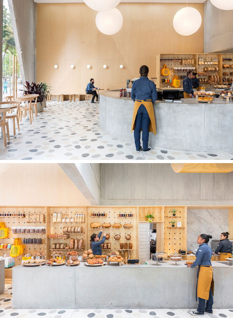 In this modern restaurant / cafe, a curved concrete service counter that extends into a straight bar area, provides the employees with plenty of room to display and sell goods. #InteriorDesign #RetailDesign #Cafe #Restaurant