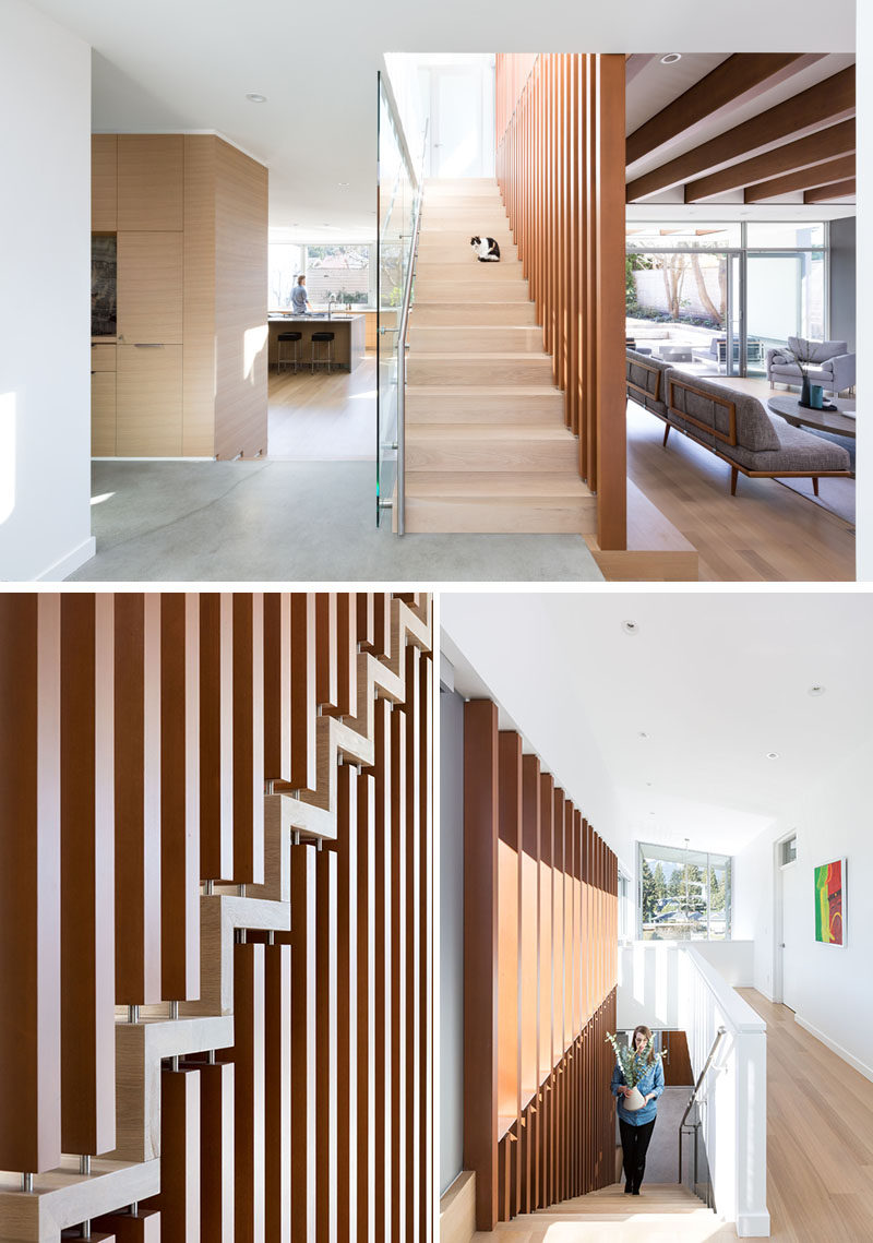 This modern and open staircase uses wood verticals to carry the eye upwards to the second floor, while large window runs the full width of the stair on the second level and allows light to enter deep into the center of the home. #Stairs #Staircase #WoodStairs #ModernStairs