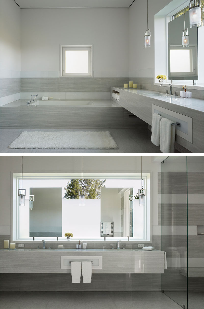 In this modern bathroom, crisp white walls have been paired with polished surfaces, dramatic lighting, and frosted windows for a contemporary appearance. #BathroomDesign #ModernBathroom