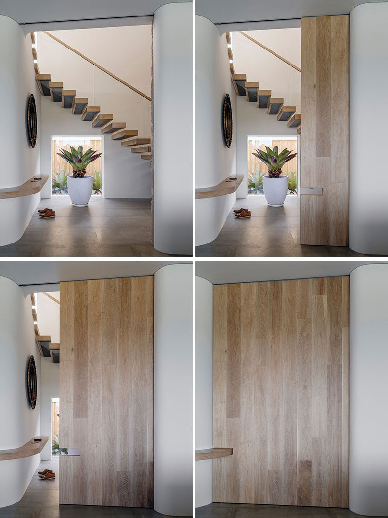 This modern Australian house features a large wooden pocket door that has a small cutout for a shelf that wraps around the wall. #PocketDoor #Door #WoodDoor #Shelf #CurvedShelf