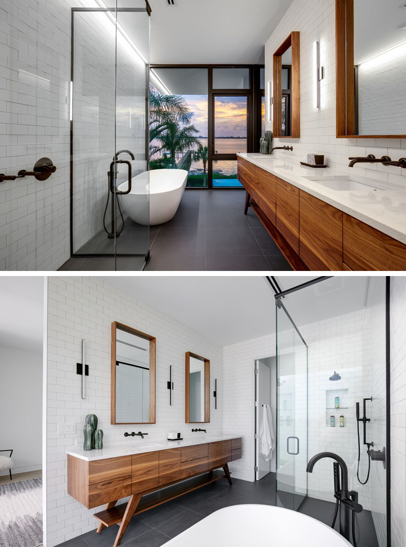 In this modern bathroom, the freestanding bathtub is positioned for water views, while the wood framed mirrors and the wood vanity add a natural touch to the white and grey bathroom. #ModernBathroom #BathroomDesign