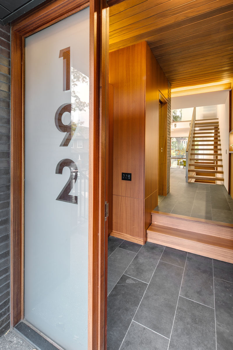 This front door, with an adjacent large glass panel showcasing the house number, guides visitors into the home. #FrontDoor