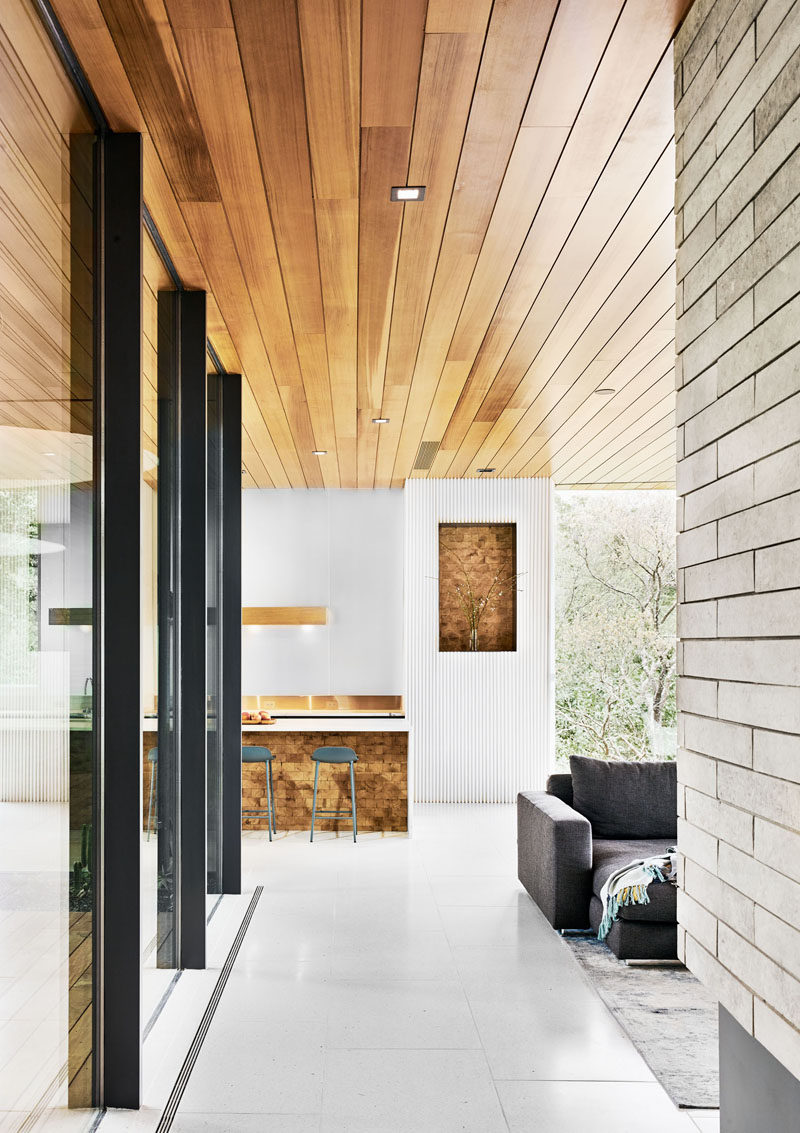 The wood ceiling of this modern house continues from the outside through to the interior, that also features white Terrazzo floors. #ModernHouse #ModernInterior #WoodCeiling #WhiteFloors