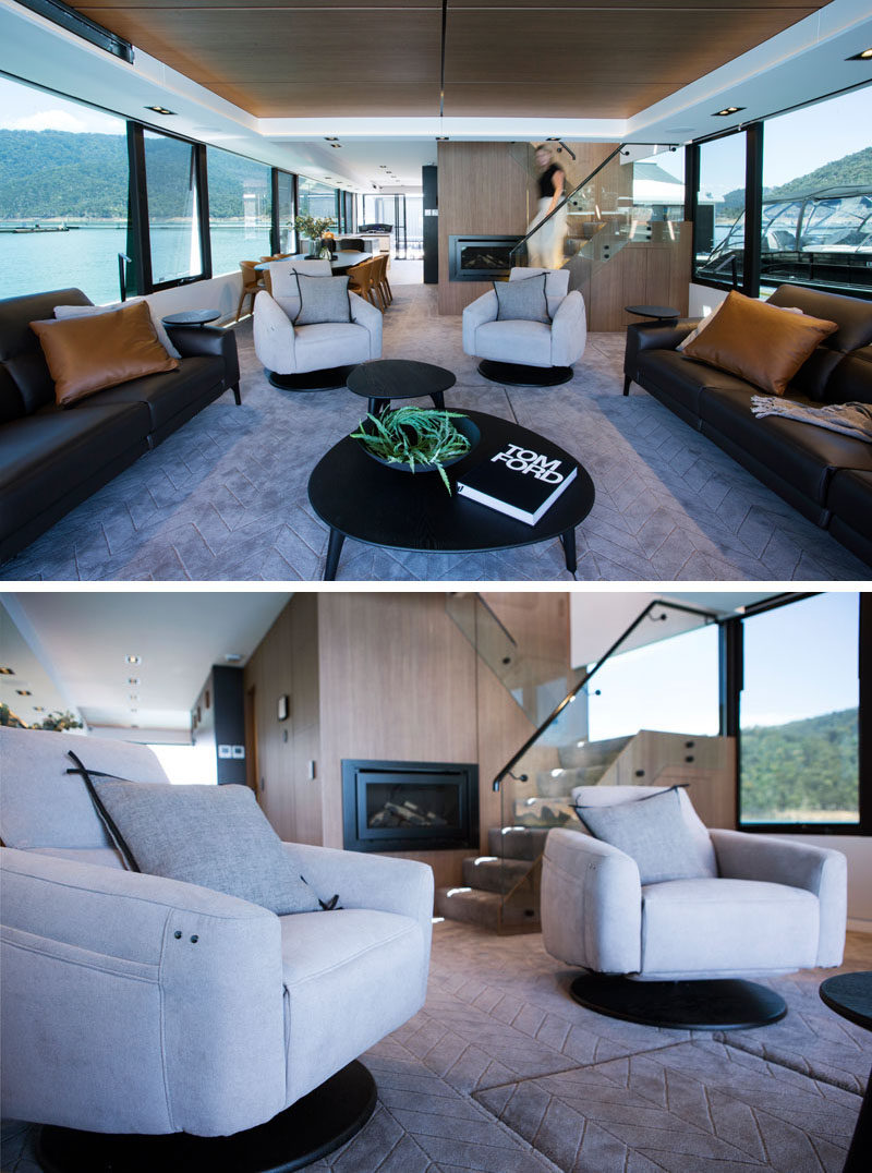 Large windows surround all of the interior spaces of this modern houseboat, like the living room. Couches on either side face opposite windows, while two armchairs look out towards the rear of the houseboat. #LivingRoom #Houseboat