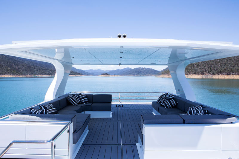 On the top of this modern houseboat, there's outdoor space in the form of a covered rooftop lounge, with couches that wrap around the corners. #Rooftop #Houseboat #OutdoorLounge