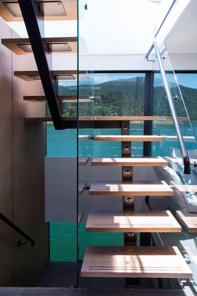 Wood stairs with steel supports connect the various levels of this modern houseboat. #Houseboat #ModernStairs