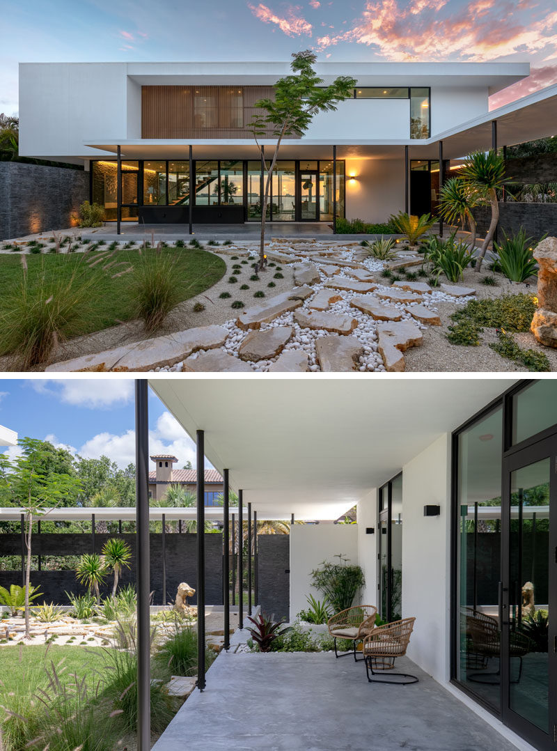 This modern house has a landscaped courtyard with stone and a small lawn, contrasts the dark limestone walls. #Landscaping #HouseDesign