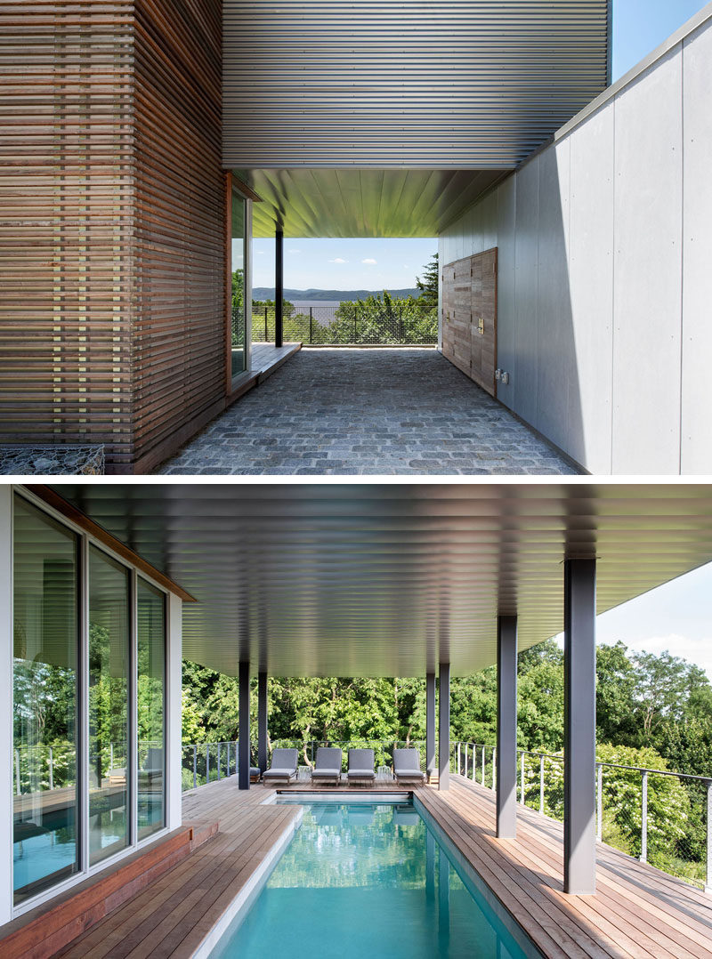 The entry to this modern house is tucked away beside the covered carport, that features metal panels that extend to cover the adjacent swimming pool and deck. #ModernHouse #Carport #SwimmingPool #Deck