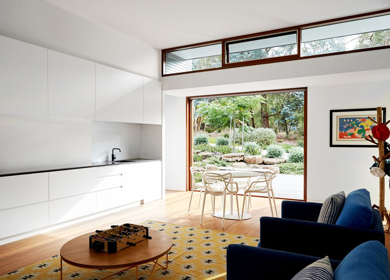 This modern play room has a wall of cabinets with a wet bar, a small dining area, and a sitting area. #InteriorDesign