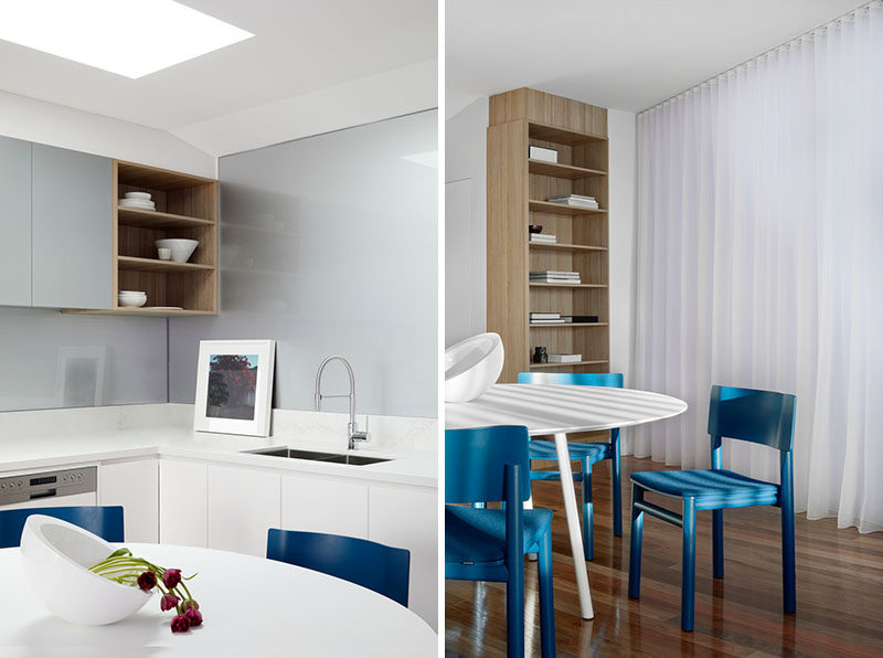 A skylight in the ceiling adds light to this modern dining area and kitchen, while blue chairs add a pop of color to interior. #Kitchen #DiningRoom