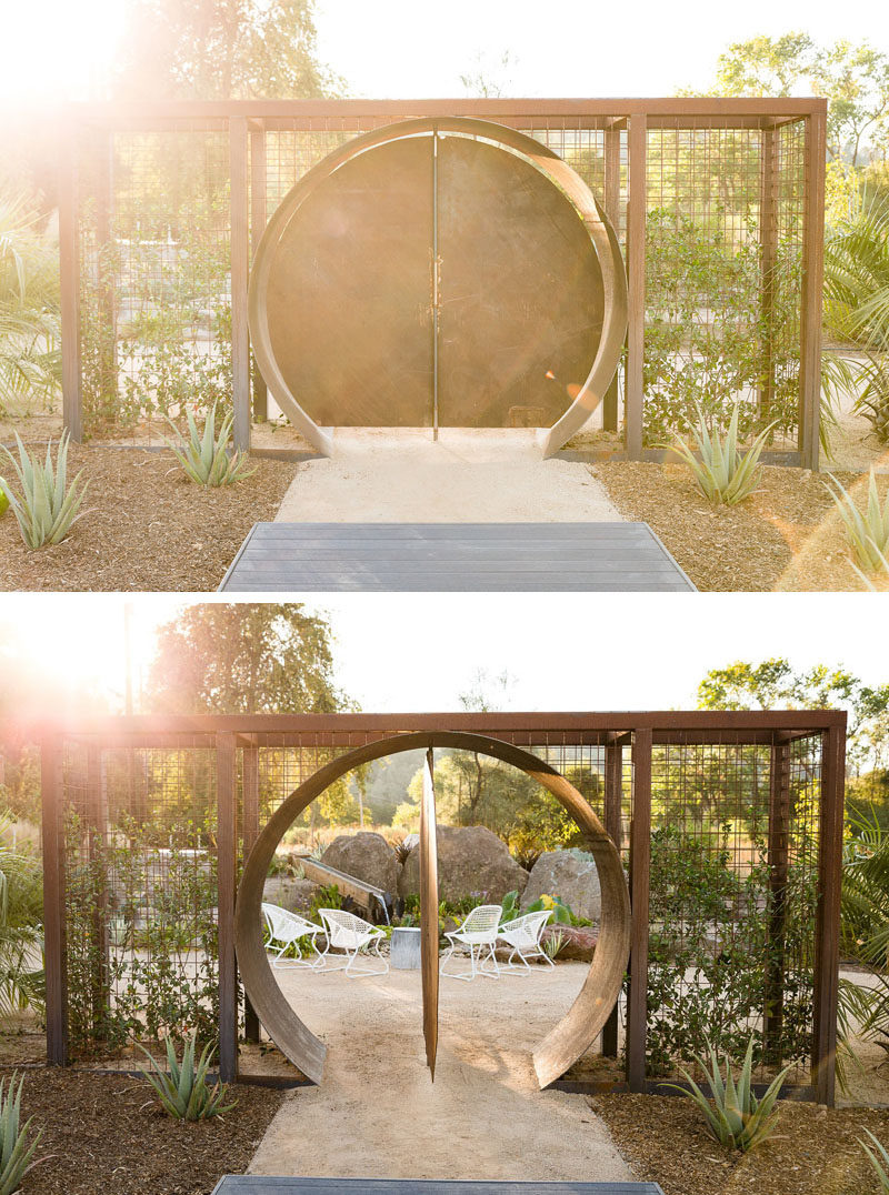 In this modern backyard, there's a circular steel doorway that opens to a peaceful sitting area. #Landscaping #LandscapeDesign