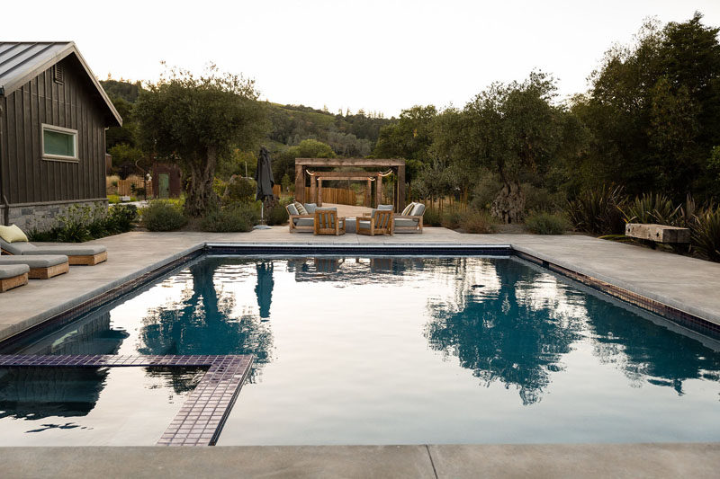 This swimming pool with a space is surrounded by a deck with a variety of seating options. #SwimmingPool