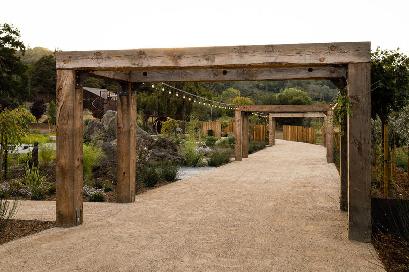 In this contemporary backyard, simple decorative lights hang between wood trellis', lighting up a gravel pathway. #Trellis #Architecture #Garden #Backyard