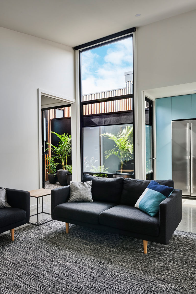 Inside this modern house, the interiors are bright and open, with high ceilings giving the sense of space, and tall windows providing ample natural light. #LivingRoom #Windows