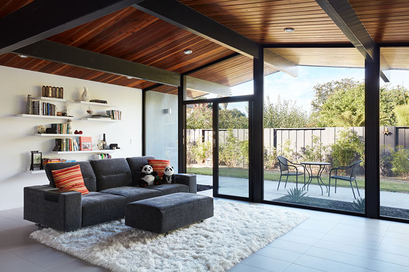 This reconfigured great room with new full height windows and sliding glass doors blends the indoors with the outdoors. #LivingRoom #Windows #ModernInterior