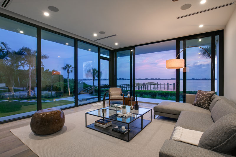 This living room has floor to ceiling windows that provide views of the backyard and water. #Windows #LivingRoom