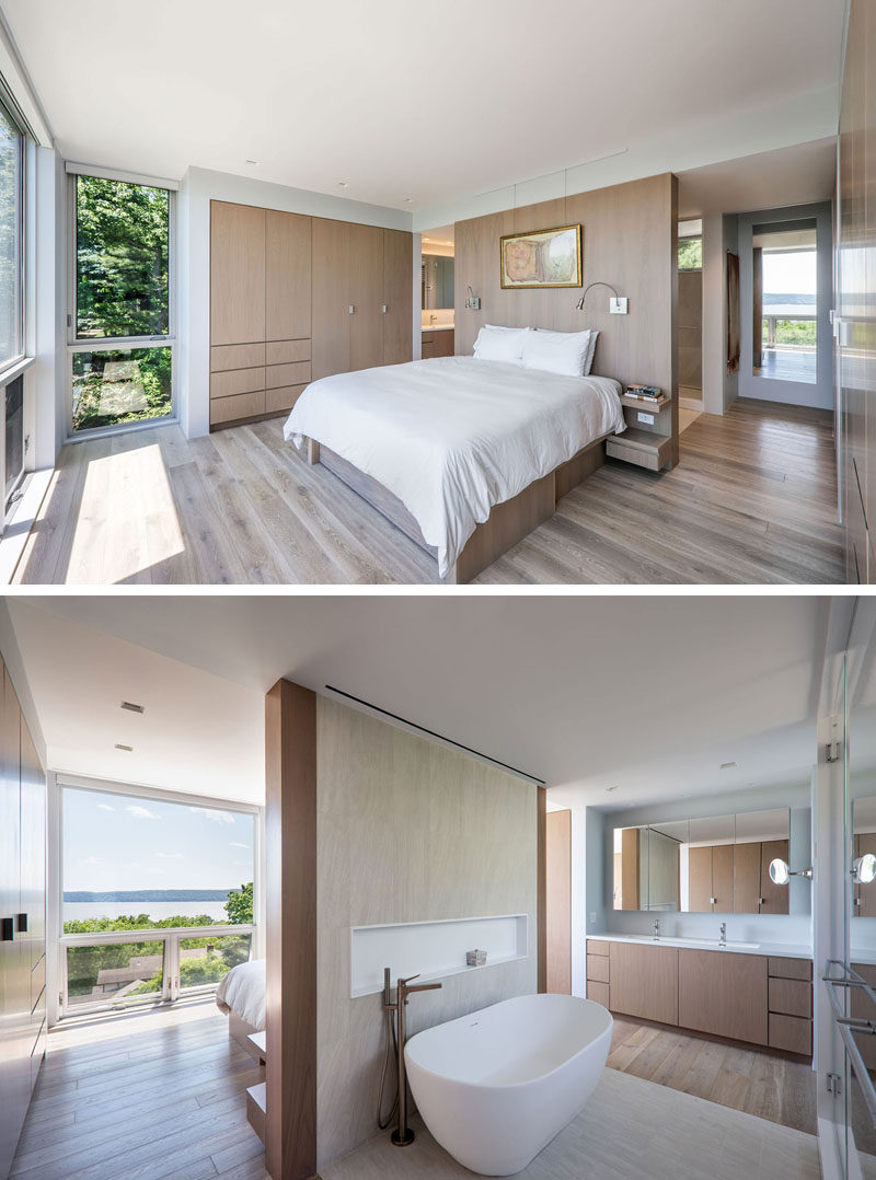 This modern master suite has the bed positioned to take advantage of the views, and an open bathroom with a freestanding bathtub and a walk-in shower. #MasterSuite #MasterBathroom #MasterBedroom #ModernBedroom