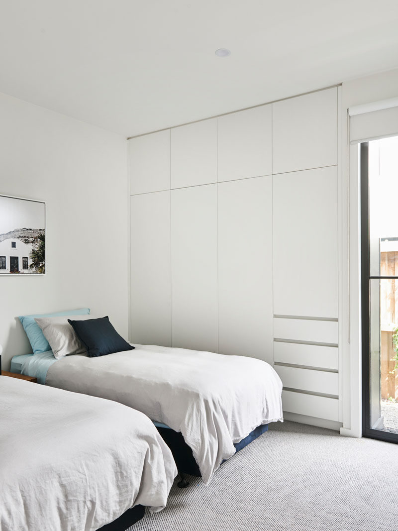 This modern bedroom has a minimal design with a built-in closet that takes up one wall. #Closet #Bedroom