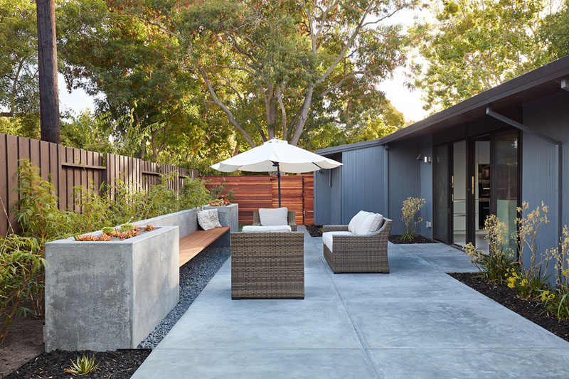 This modern patio area has a built-in wood and concrete bench, that features planters on either end. #Landscaping #OutdoorSeating #Patio