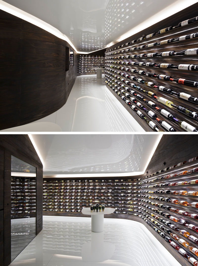 Studio Arthur Casas have designed a wine store and bar in Sao Paulo, Brazil, that features walls of dark wood that showcase the available wines. #WineStore #RetailDesign #WineBar #WineStorage