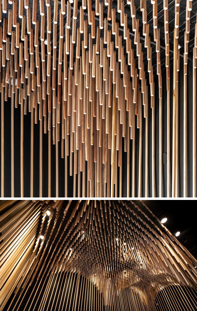 This modern retail store features 1954 broomsticks (commemorating the year of the founding of the family business), that were used to create a sculptural wood ceiling installation. #ModernRetailStore #StoreDesign #WoodCeiling