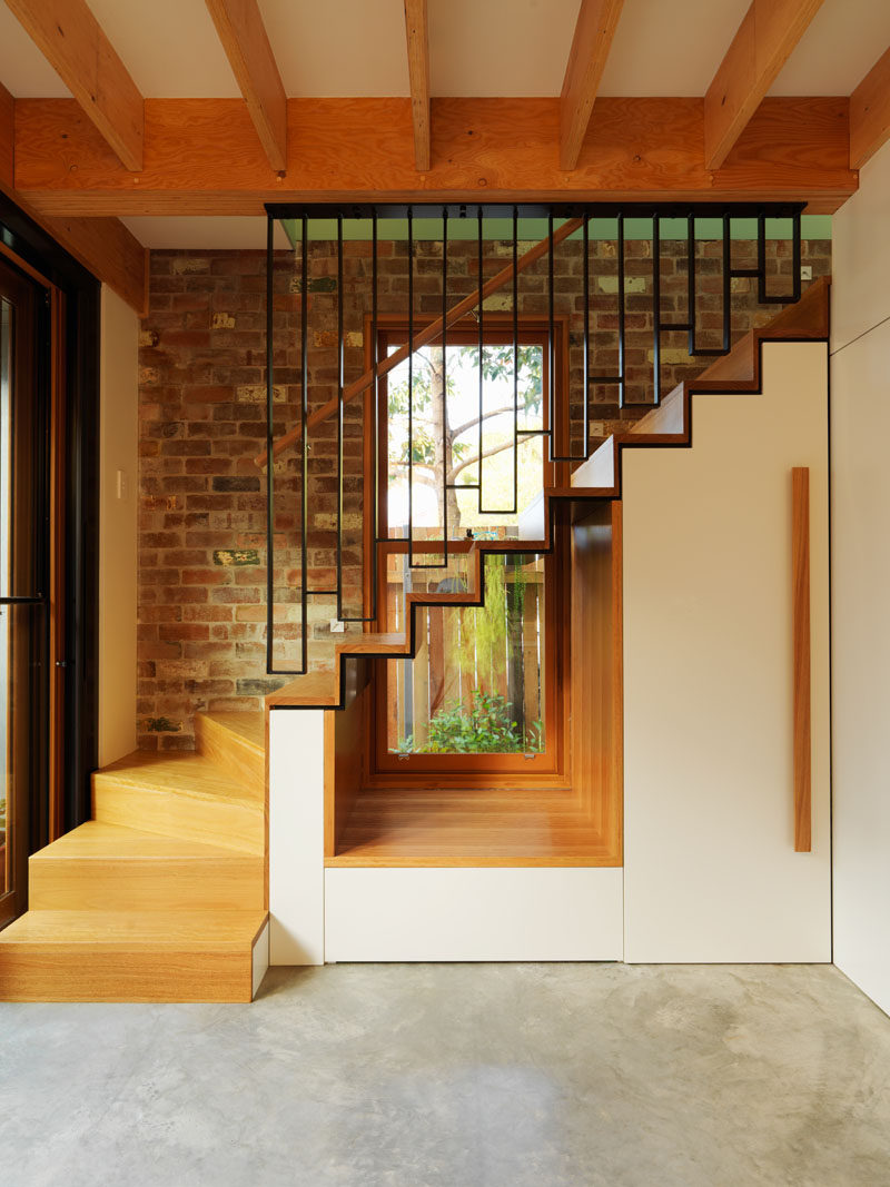 This modern house has a cut-out underneath the stairs to allow the light from the window to flow through to the interior. #Stairs #InteriorDesign #Window