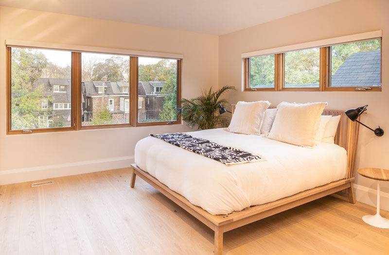 In this bedroom, rows of wood-framed windows fill the minimally furnished room with an abundance of natural light. #Bedroom #Windows