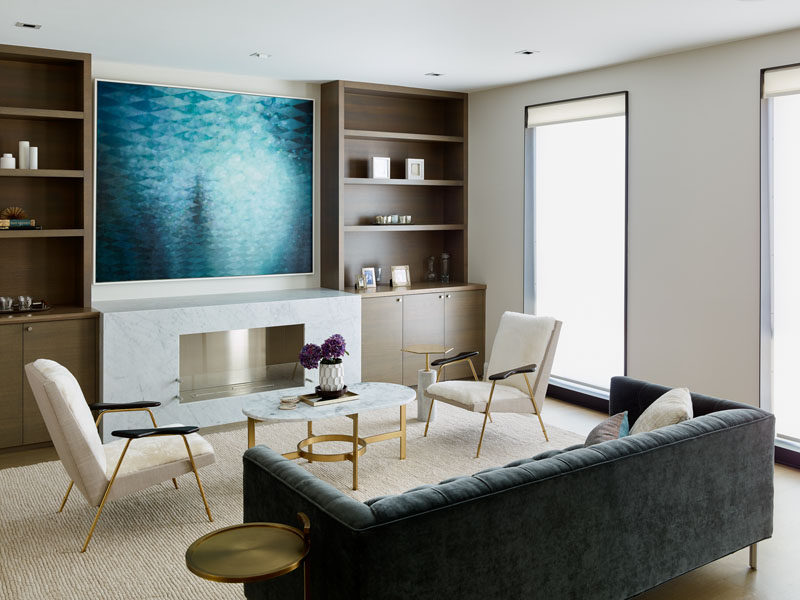 This contemporary living room has built-in wood cabinetry that sits beside the fireplace. #LivingRoom #Shelving