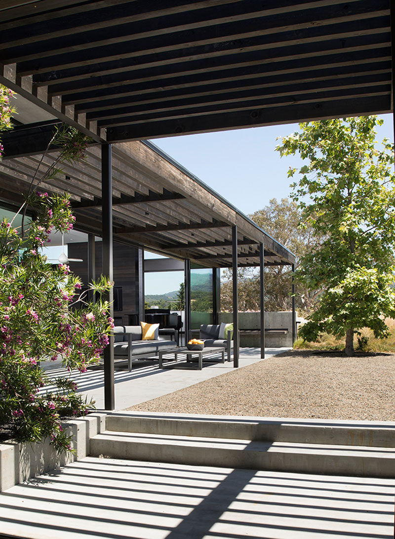 A pergola follows this modern house's L-shaped layout, creating shade for the outdoor lounge. #Pergola #ModernHouse