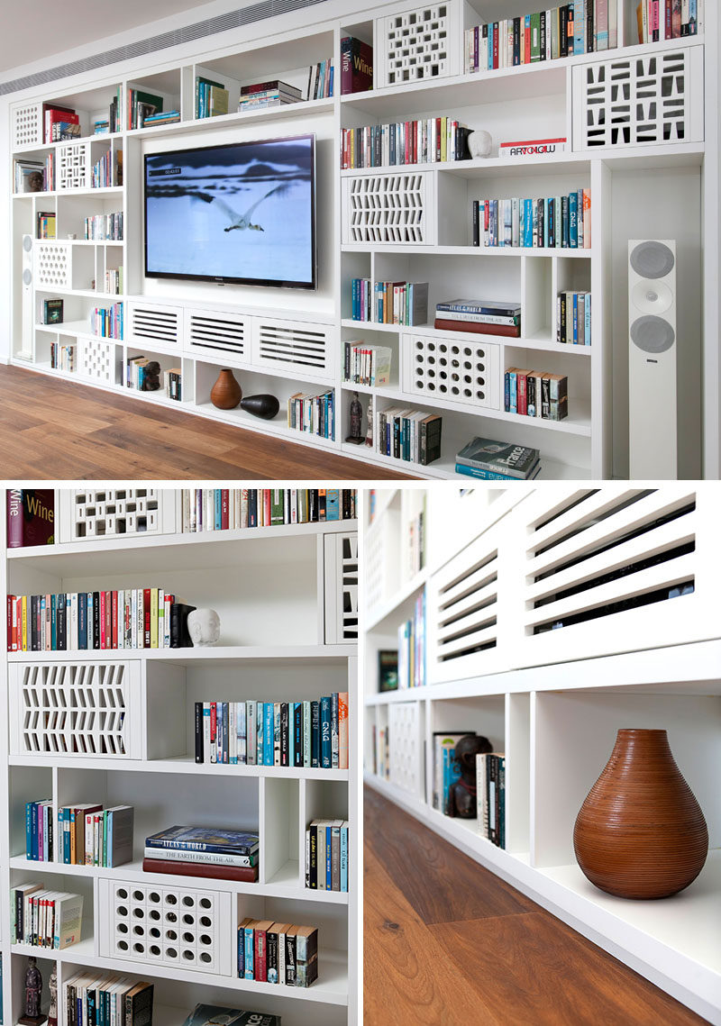 This modern apartment has a custom-designed shelving unit in the living room, that's filled with playful patterns and plenty of storage. #Shelving #LivingRoom #Library #Bookshelf