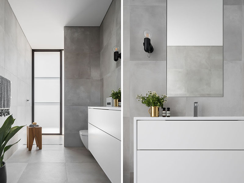 In this bathroom, a simple grey and white color palette has been used for a modern and calming appearance. #ModernBathroom #BathroomDesign