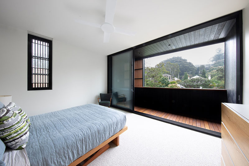 This bedroom has minimal furnishings, however it has sliding glass doors that open up to a balcony with treetop views. #ModernBedroom #Balcony