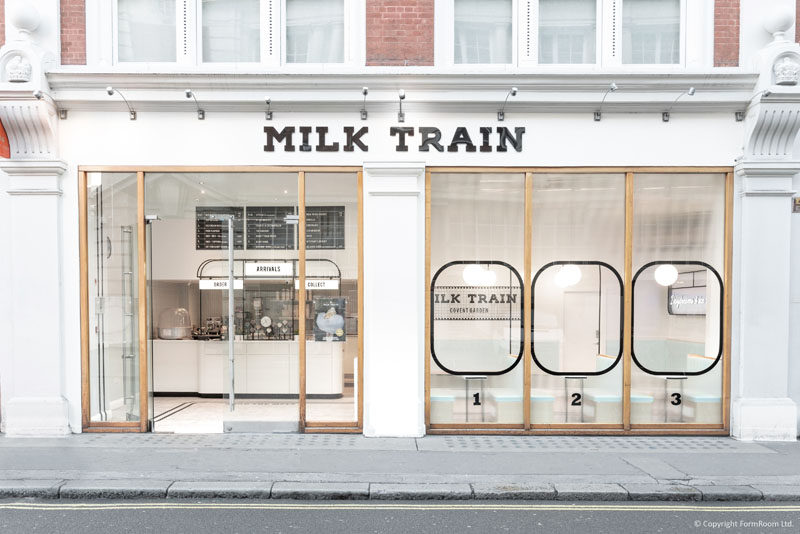 Inspired by trains and train stations, the exterior of the 'Milk Train Cafe' utilizes beaded opaque glass to mimic the steaming of a train window, whilst the black metal detailing lends another subtle nod to the brand’s immersive train experience. #CafeDesign #IceCreamStore #RetailDesign