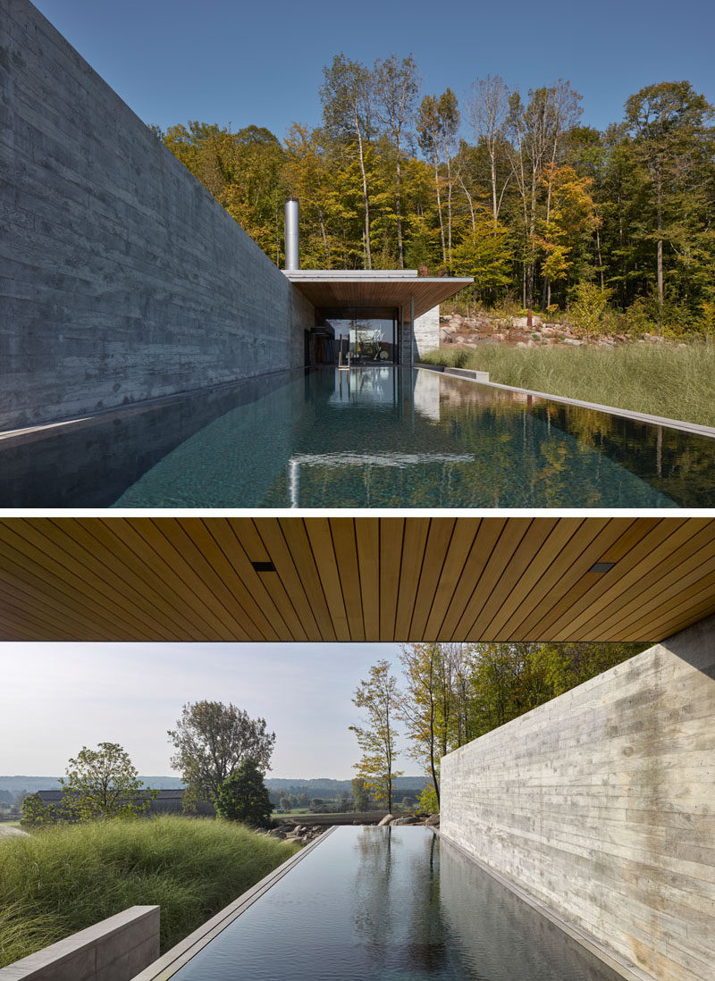 This modern concrete, wood, and glass pool house sits next to an infinity lap pool and hot tub, and features an outdoor fireplace, a gym, lounge, and changing areas. #PoolHouse #SwimmingPool #Architecture