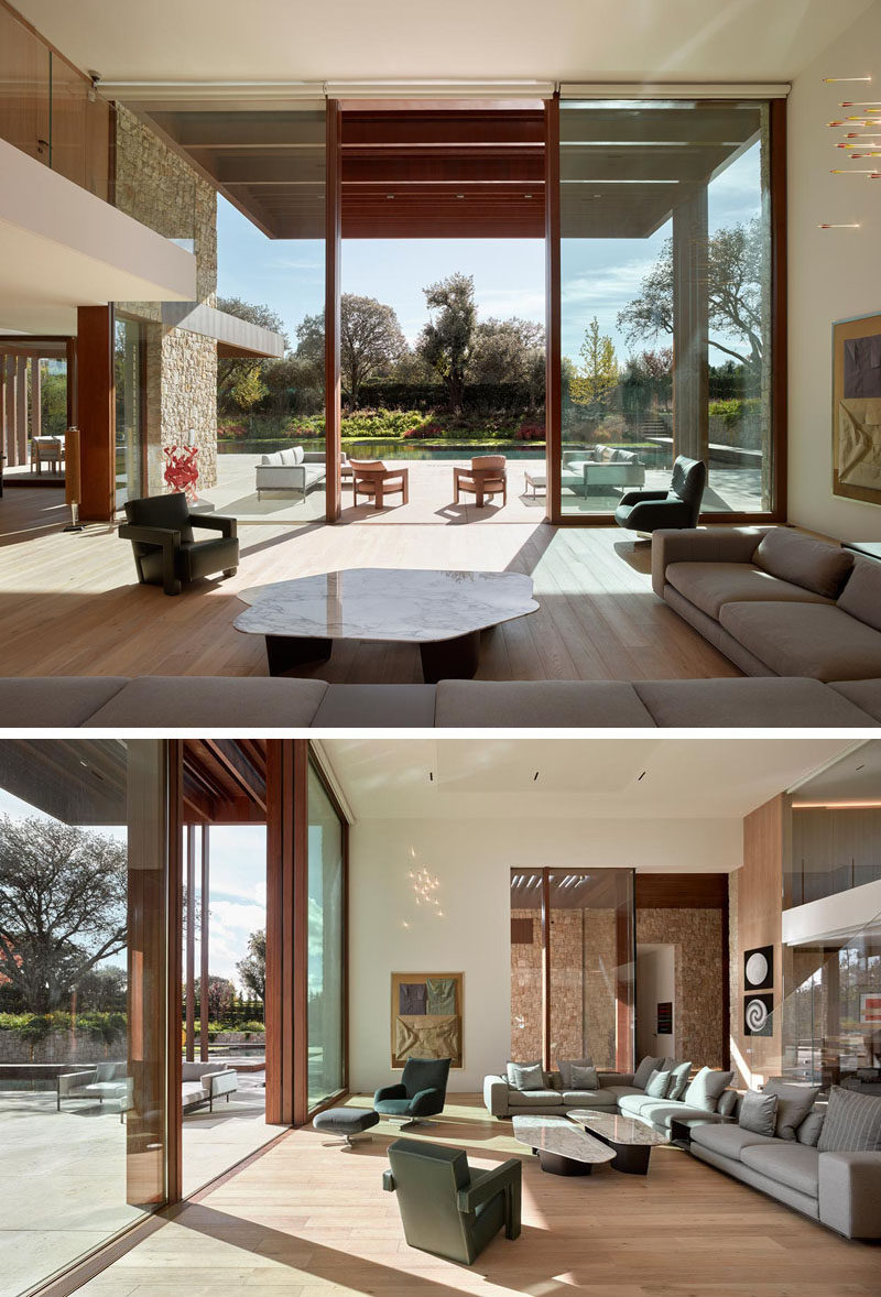 Inside this modern house, double height ceilings in the living room create an open gallery-like atmosphere. #LivingRoom #HighCeilings