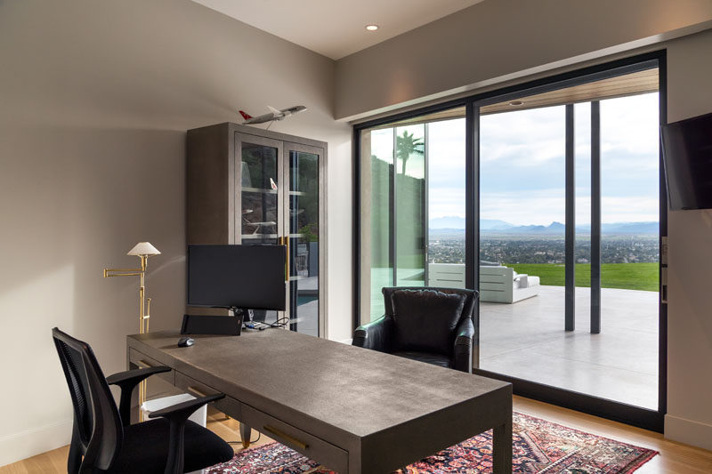 This modern home office has a neutral color palette and sweeping views of the valley. #HomeOffice