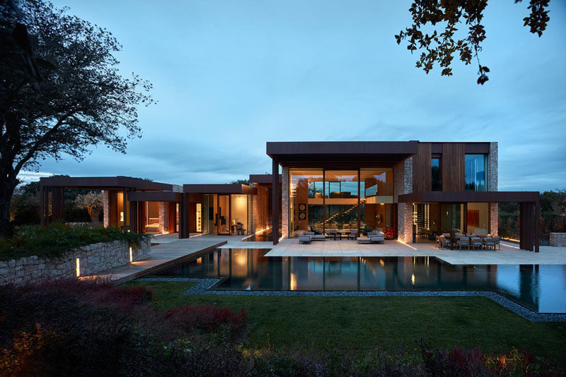 Surrounded by lush vegetation and some ancient Holm oak trees, the house was designed around the trees to respect the land. #ModernHouse #Architecture
