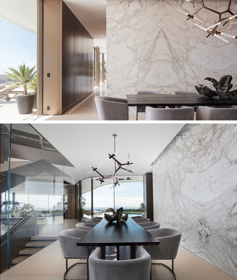 In this contemporary dining room, a stone wall adds a natural touch to the interior, while a minimalist sculptural light hangs above the dining table. #DiningRoom #StoneWall