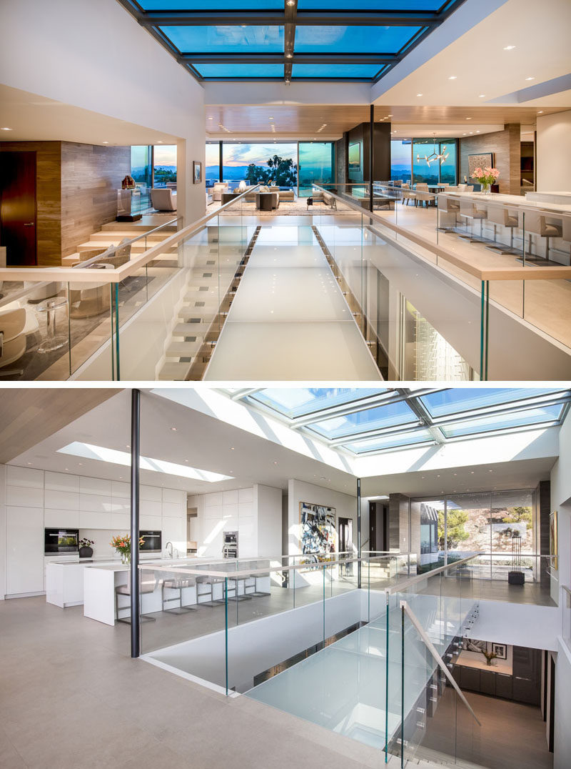 This modern house has a glass bridge that sits below a large skylight, that provides light to the social areas of the house, as well as the lower level. #GlassBridge #Skylight