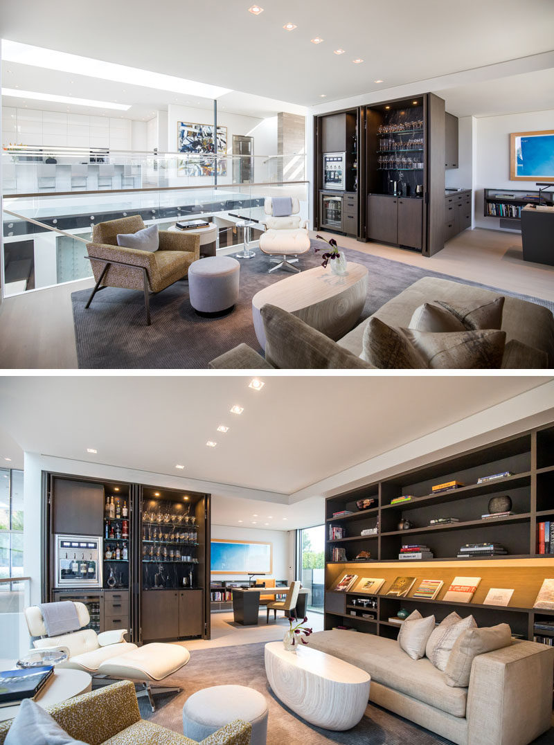 This modern house a library seating area with a built-in bar cabinet, which are open to the central volume and an adjoining home office. #Library #HomeLibrary #Bar #HomeOffice