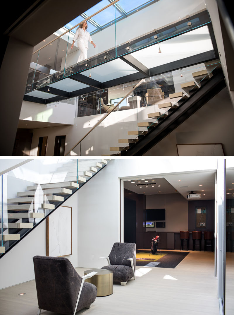 This modern house has floating stairs that lead down to the bottom level of the home. The downstairs courtyard area, lit by the skylight, includes a small seating area and wine storage. #Stairs #ModernStairs #Skylight