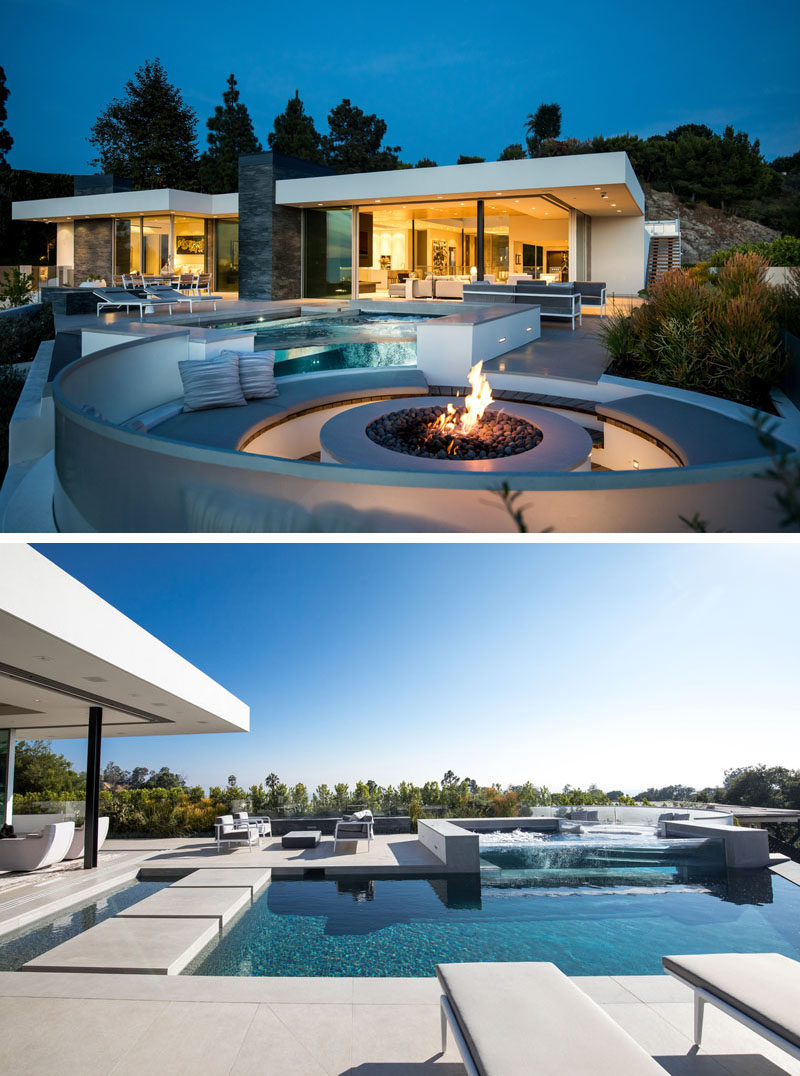 At the back of this modern house, two walls of glass glide open to provide easy access to the pool and patio entertaining spaces, including a circular fire pit with seating. #Patio #SwimmingPool #FirePit