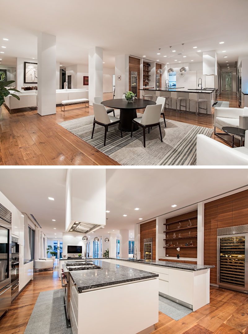 In this modern kitchen, white cabinets are paired dark countertops and wood accent walls featuring open shelving. #Kitchen #KitchenDesign