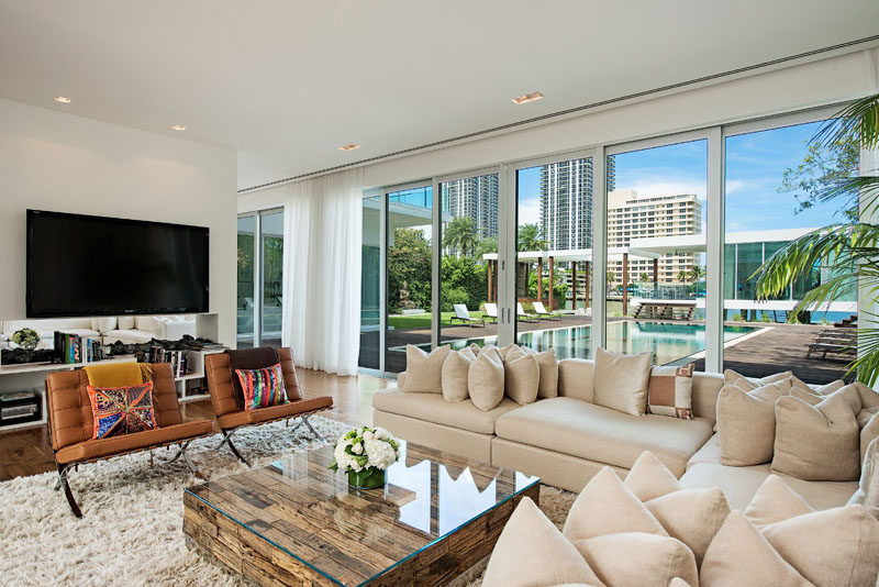 Sliding glass doors open this living room to the wood deck that surrounds the swimming pool. #LivingRoom