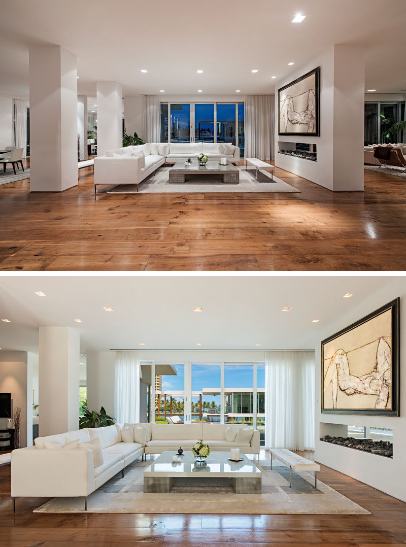 Inside this modern house, European white oak floors are featured throughout, and a double-sided fireplace is positioned between two living rooms. #WoodFlooring #LivingRoom #Fireplace